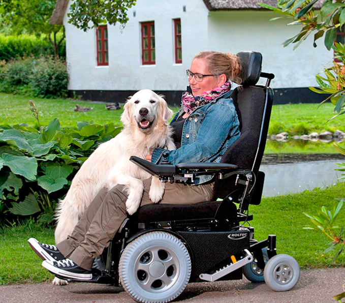 junge-Frau-mit-Hund-im-Garten-in-einem-Eletrorollstuhl-der-Marke-Roltec